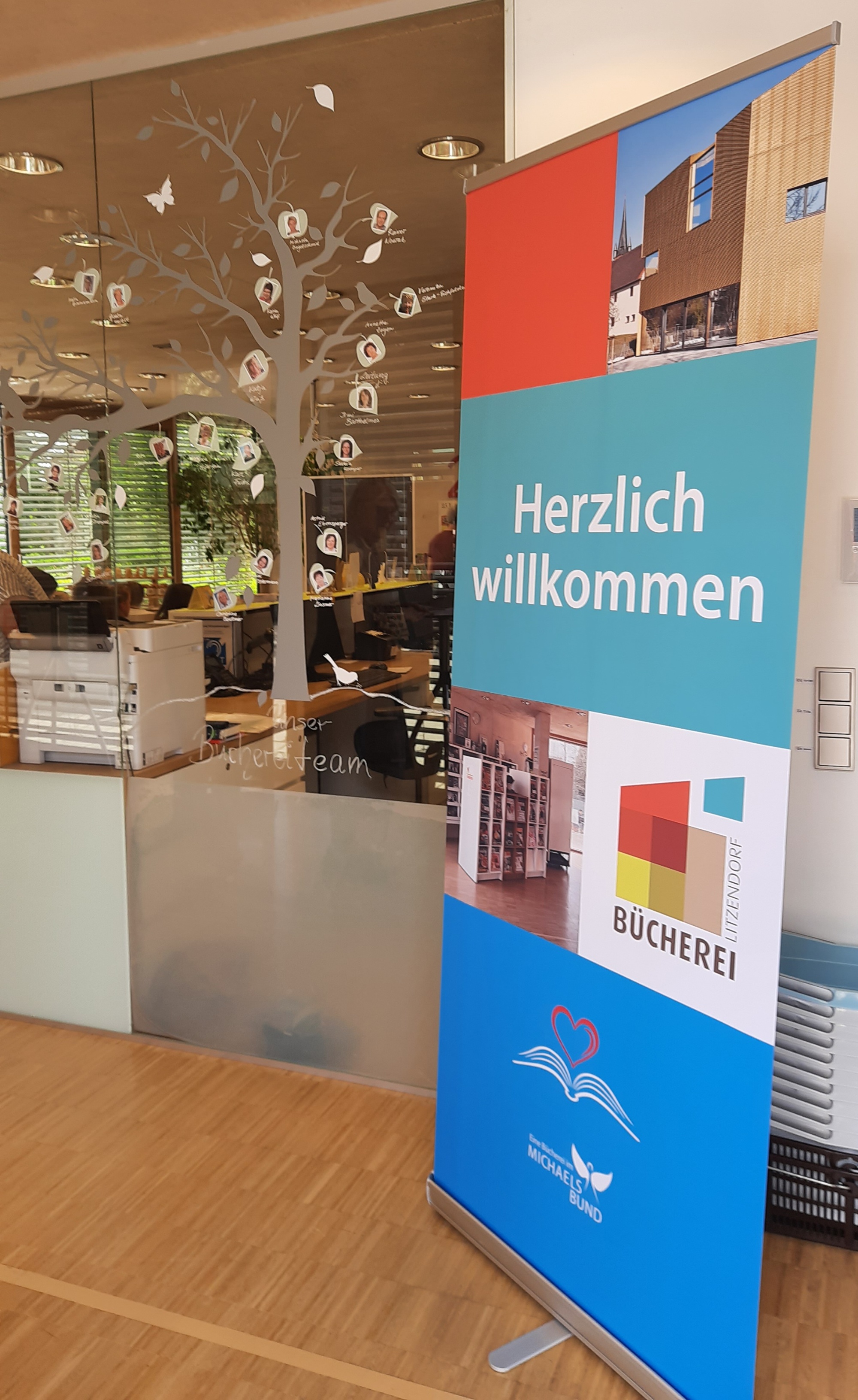 Plakataufstellen im Eingangbereich der Bücherei mit Aufschrift Herzlich Willkommen
