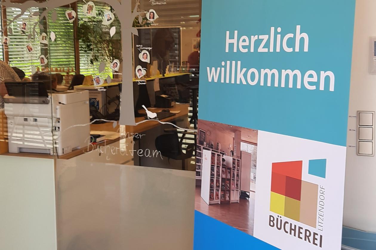 Plakataufstellen im Eingangbereich der Bücherei mit Aufschrift Herzlich Willkommen