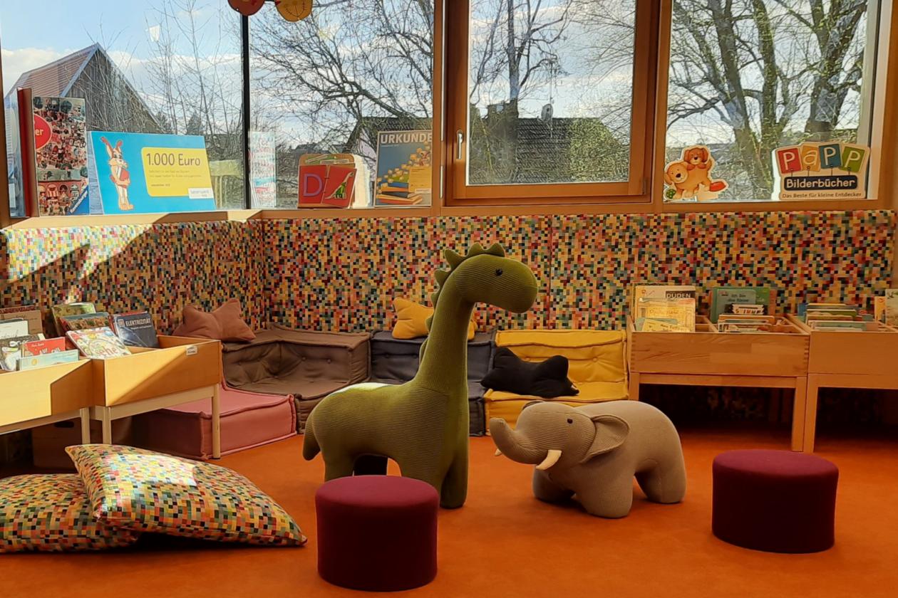 Kinderbereich mit Stofftieren und Sitzgelegenheiten